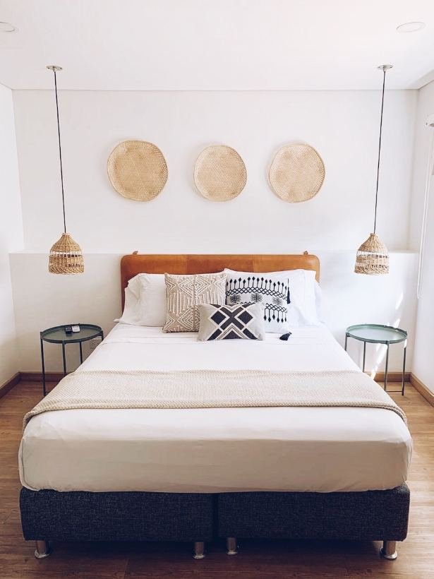 Habitación Deluxe con cama Queen, canastos tejidos y lámparas gemelas de ratán