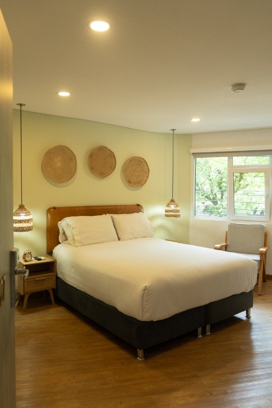 Balcony Room with queen bed, leather headboard and woven basket wall decor