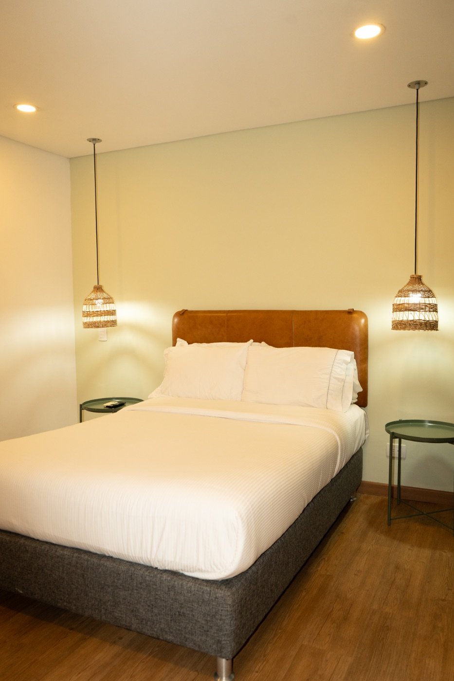 XS Room with full bed, leather headboard and twin rattan pendant lamps